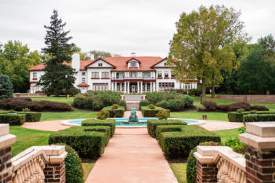 wide-angle exterior of completed longview mansion development project with fountain and bushes